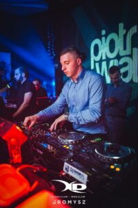 Piotr Wiater miksujący za konsolą DJ-ską w klubie we Wrocławiu