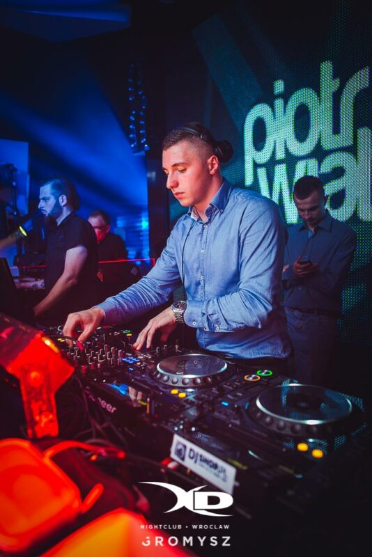 Piotr Wiater miksujący za konsolą DJ-ską w klubie we Wrocławiu