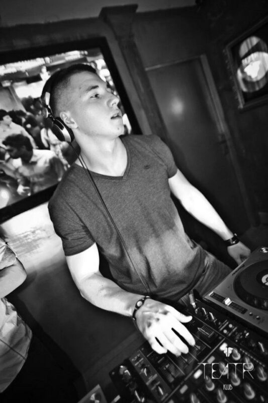 Czarno-białe zdjęcie DJ-a przy gramofonach w klubie